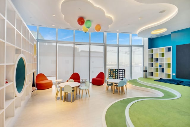 game room with a wall of windows and light hardwood / wood-style floors