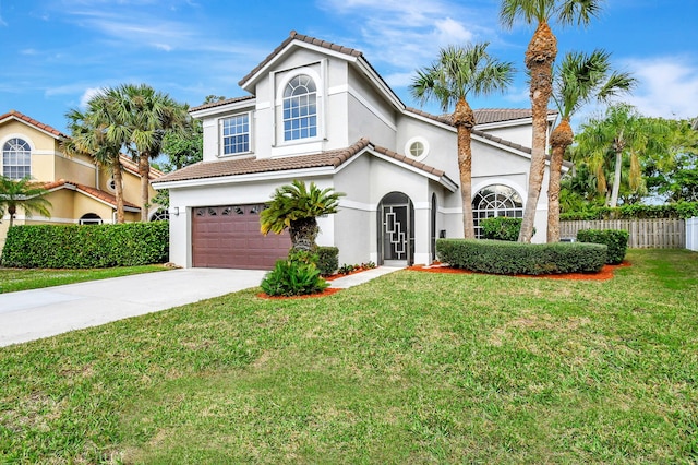 mediterranean / spanish house featuring a garage and a front yard