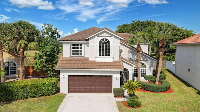 mediterranean / spanish home with a garage and a front lawn