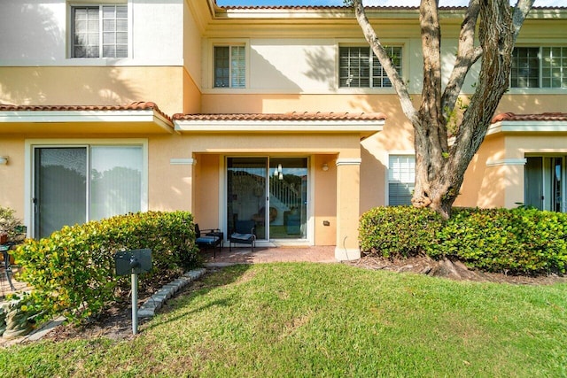 rear view of property with a lawn and a patio