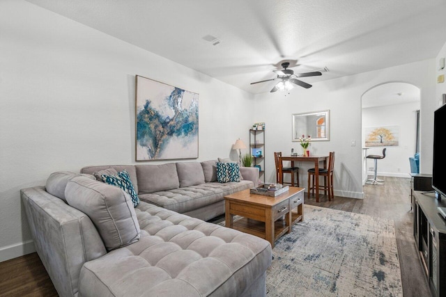 living room featuring ceiling fan and dark hardwood / wood-style floors