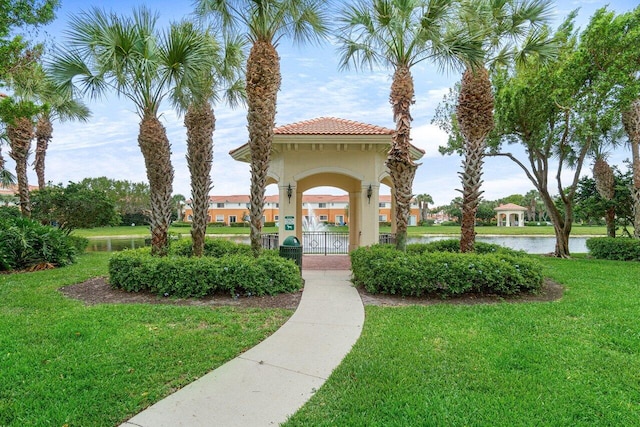 view of home's community with a water view and a lawn