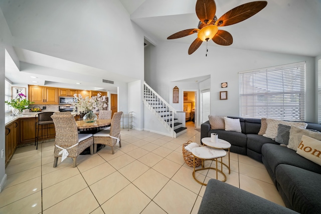 tiled living room featuring high vaulted ceiling and ceiling fan