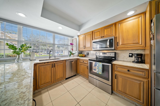 kitchen featuring tasteful backsplash, appliances with stainless steel finishes, light tile patterned flooring, and sink