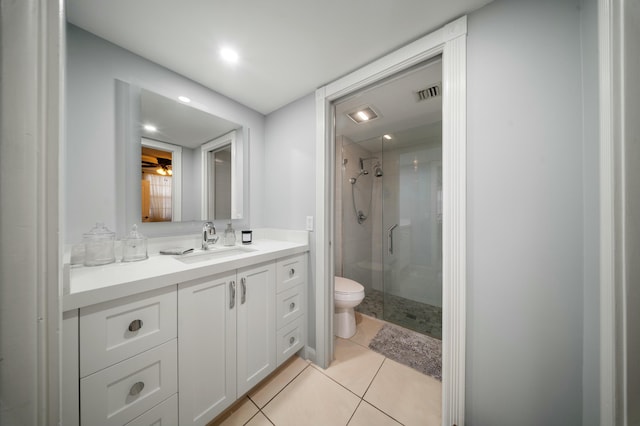 bathroom with vanity, tile patterned flooring, toilet, and walk in shower