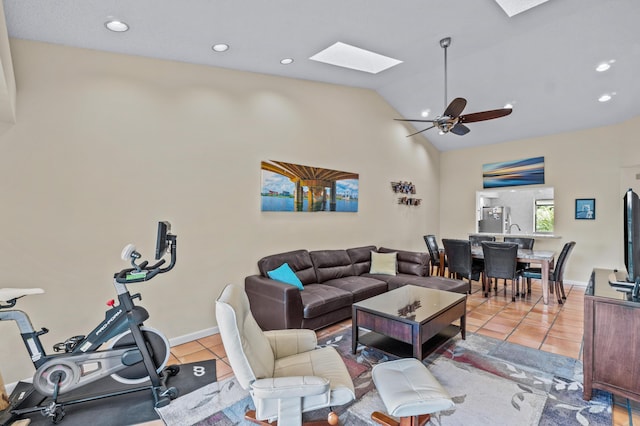 living room with light tile patterned flooring, ceiling fan, and lofted ceiling with skylight