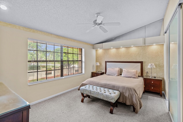 bedroom featuring lofted ceiling, ceiling fan, light colored carpet, and a textured ceiling