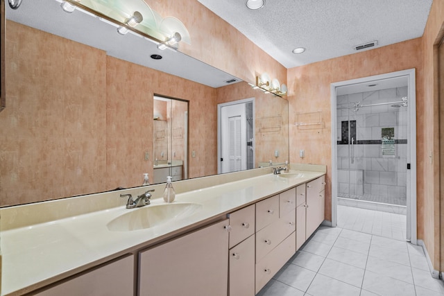 bathroom featuring tile patterned floors, vanity, a shower with door, and a textured ceiling