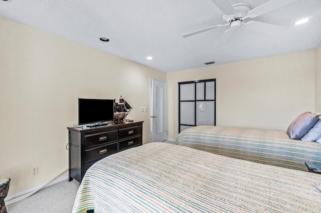 carpeted bedroom with ceiling fan and a textured ceiling