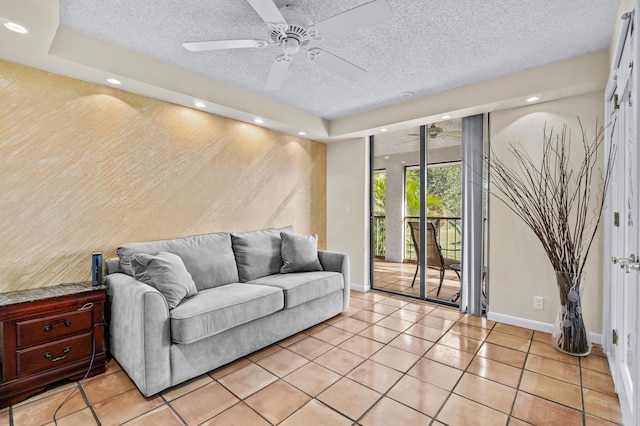 tiled living room with ceiling fan and a textured ceiling