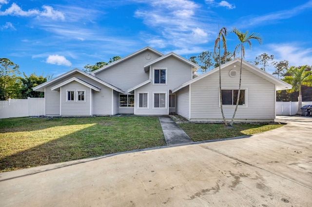 traditional-style house with a front lawn and fence