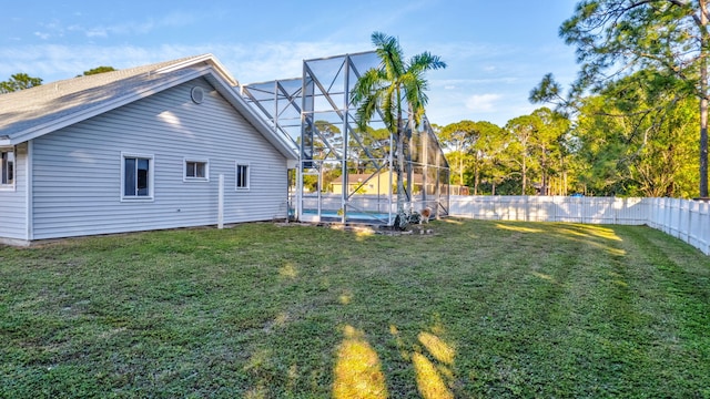 view of yard featuring a fenced in pool and glass enclosure