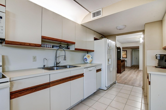 kitchen featuring white cabinetry, sink, light tile patterned flooring, and white appliances