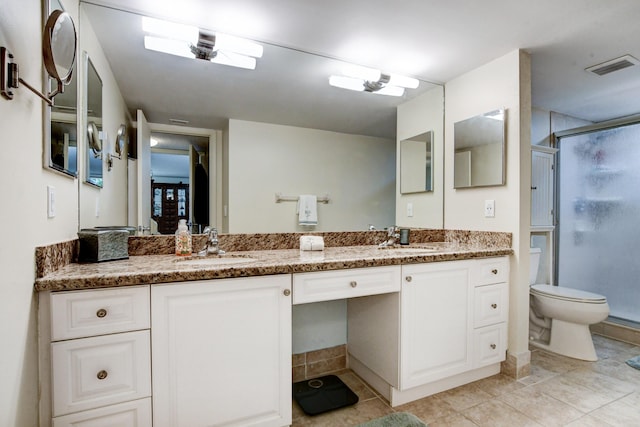 bathroom with tile patterned floors, vanity, toilet, and a shower with door