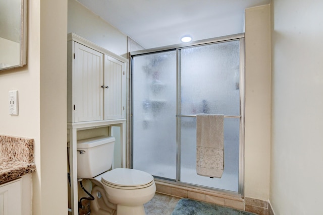 bathroom featuring vanity, toilet, and a shower with shower door