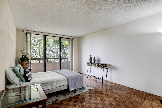 bedroom featuring parquet floors and a textured ceiling