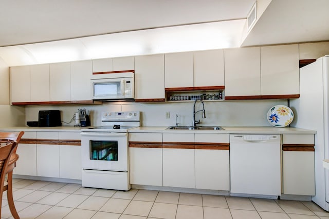 kitchen featuring sink, light tile patterned floors, white cabinets, and white appliances