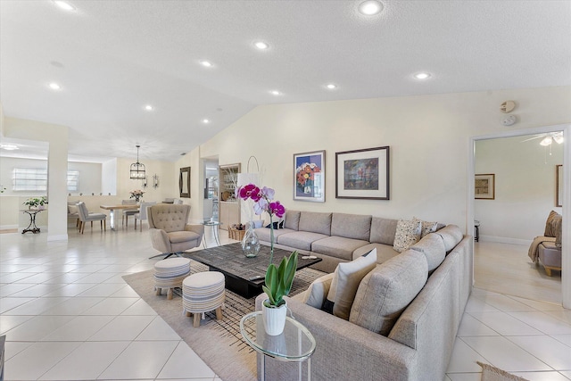 living room with light tile patterned flooring, vaulted ceiling, and a textured ceiling