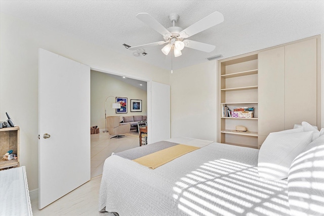 tiled bedroom featuring ceiling fan and a textured ceiling