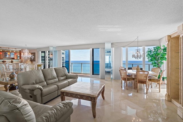 living room featuring a water view, a chandelier, and a textured ceiling