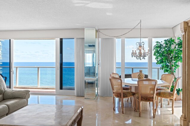 dining room with a water view and a chandelier