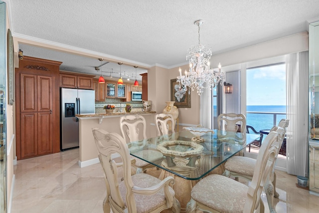 dining area featuring crown molding, a textured ceiling, a chandelier, and a water view