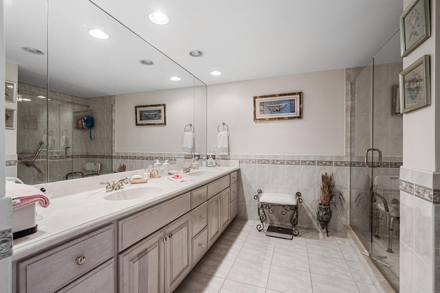 bathroom with vanity, a shower with shower door, tile patterned floors, and tile walls