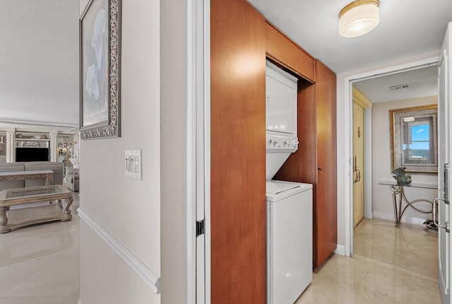 laundry area featuring stacked washer / dryer