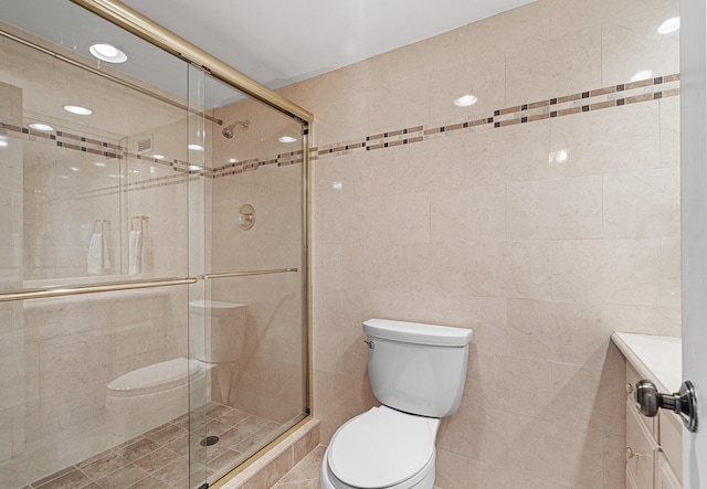 bathroom featuring an enclosed shower, vanity, tile walls, and toilet