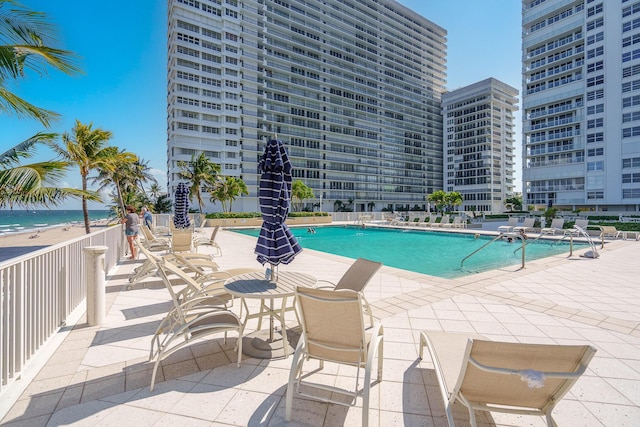 view of swimming pool featuring a water view and a patio area