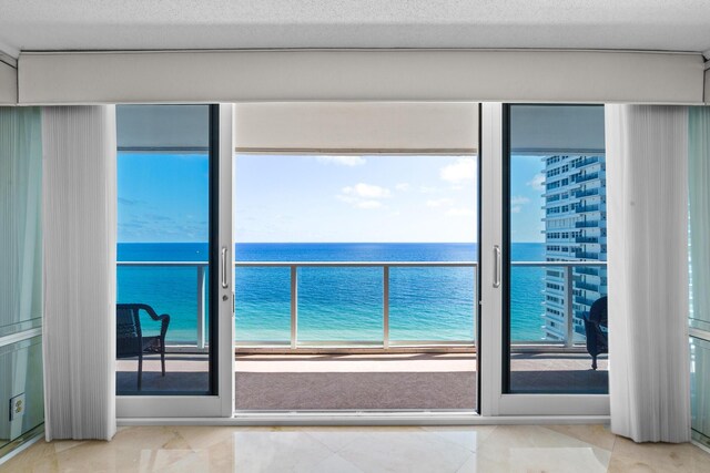 living room featuring a water view, a chandelier, and a textured ceiling