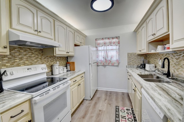 kitchen with sink, light wood-type flooring, light stone countertops, white appliances, and cream cabinetry