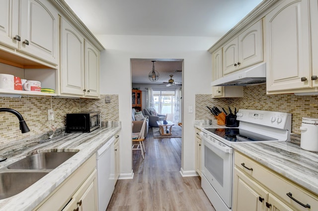 kitchen with sink, white appliances, light hardwood / wood-style floors, decorative backsplash, and cream cabinetry