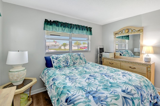 bedroom with dark hardwood / wood-style floors