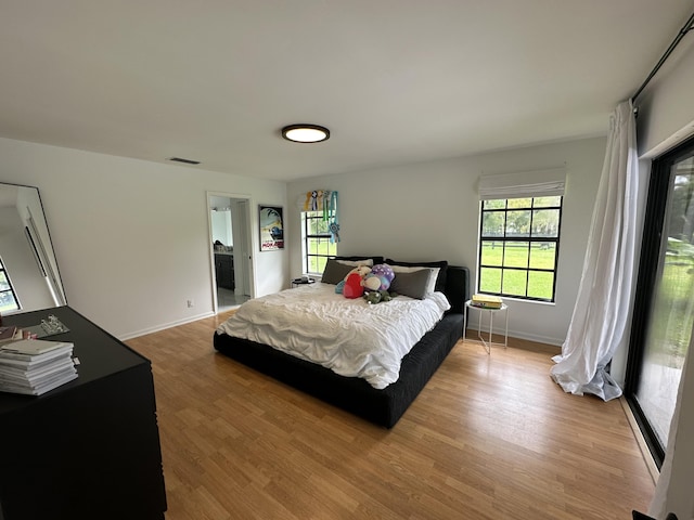 bedroom featuring multiple windows and light hardwood / wood-style flooring