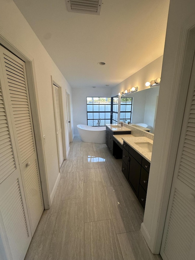 bathroom featuring vanity, wood-type flooring, and a bathing tub