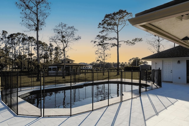 pool at dusk featuring a patio area