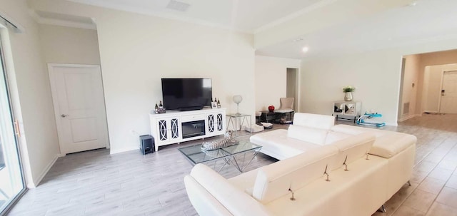 living room featuring crown molding and light hardwood / wood-style flooring