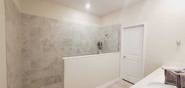 bathroom with vanity and a tile shower