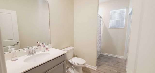 bathroom with hardwood / wood-style flooring, vanity, and toilet