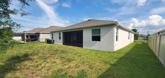 rear view of property featuring a lawn