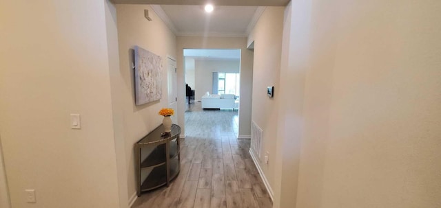 corridor with crown molding and light hardwood / wood-style floors