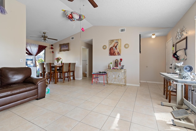 tiled living room featuring ceiling fan, vaulted ceiling, and a textured ceiling