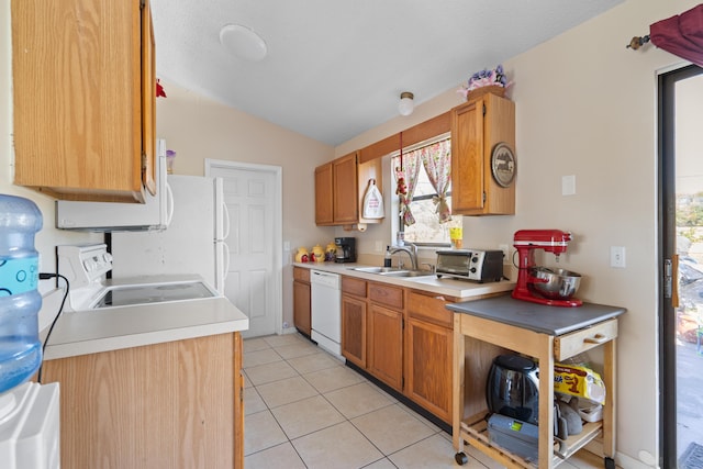 kitchen with vaulted ceiling, light tile patterned flooring, dishwasher, sink, and stove