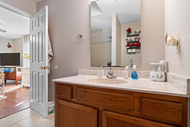 bathroom with vanity, a shower, tile patterned floors, and a textured ceiling