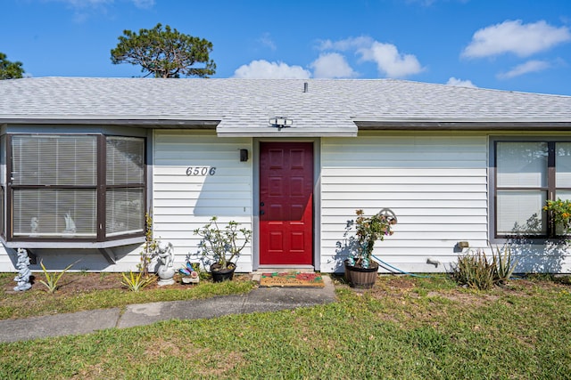 property entrance with a lawn