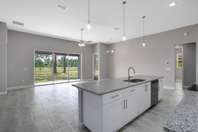 kitchen featuring an island with sink, sink, stainless steel dishwasher, and white cabinets