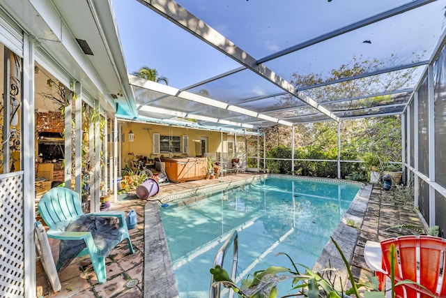 view of swimming pool featuring a lanai, a hot tub, and a patio