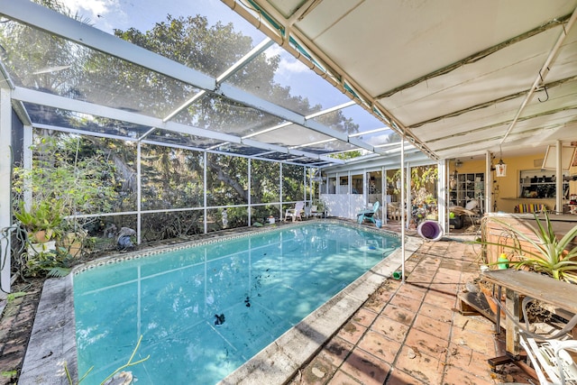 view of swimming pool featuring glass enclosure and a patio area