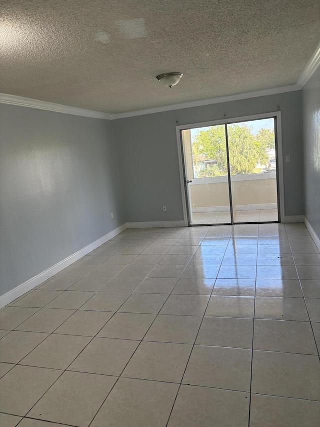 empty room with light tile patterned flooring, a textured ceiling, baseboards, and ornamental molding